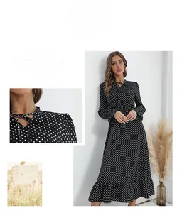 Détail du col en V avec lien à nouer sur une robe longue à pois noirs et blancs