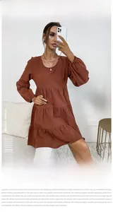 Detail of rust red tiered cotton linen dress with ruffled texture and smocked sleeves