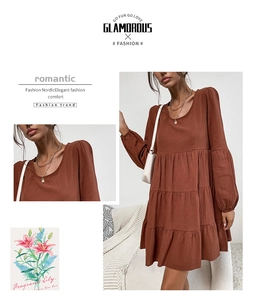 Detail of rust brown tiered cotton linen dress with long sleeves and elastic cuffs