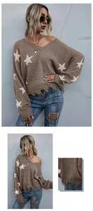 Close-up detail of white star patterns and distressed tassel hem on brown knit sweater