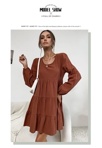 Detail view of caramel brown tiered cotton linen maxi dress with long sleeves and round neck