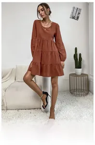 Detail of rust red layered cotton linen dress featuring puffed long sleeves and crew neck