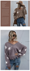 Macro shot of V-neck knit sweater featuring star prints and distressed fringe hem detail