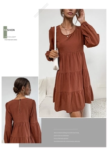 Detail of rust red tiered cotton linen dress featuring balloon sleeves and back zipper