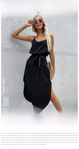 Detailed close-up of a black satin slip dress with waist tie and side slit detail