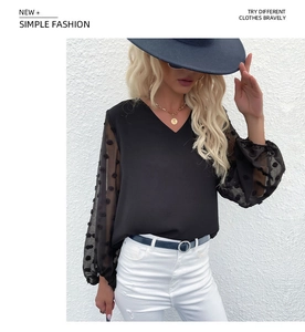 Detail of sheer mesh long sleeves with velvet polka dots on a black V-neck chiffon blouse