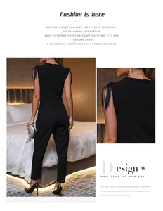 Détail d'une combinaison sans manches noire avec franges aux épaules et coupe ajustée à la taille