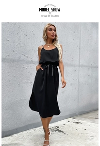 Detail view of black midi slip dress featuring thin straps and waist tie with side slit