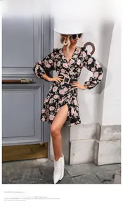 Detail of floral wrap dress with V-neck, rose print, and pearl belt in street setting