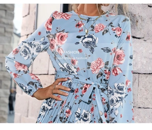 Dettaglio vestito floreale azzurro con gonna a pieghe rose e cintura in vita annodata