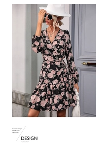 Detail of the V-neck wrap design and floral pattern on a black long sleeve dress