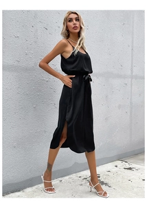 Detail of a black satin midi dress featuring a side slit and elegant drawstring waistline