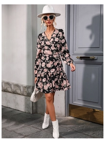 Close-up of black wrap dress featuring pink rose floral print and ruffled hem detail