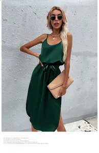 Detail of emerald green satin slip dress featuring waist tie and side slit design