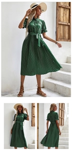 Détail d'une robe plissée à pois verts avec manches bouffantes et ceinture nouée