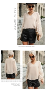 Detail view of apricot V-neck blouse with elegant textured pom-pom lantern sleeves