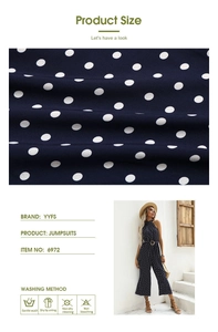 Detailed fabric texture of navy polka dot jumpsuit with halter neck and washing labels