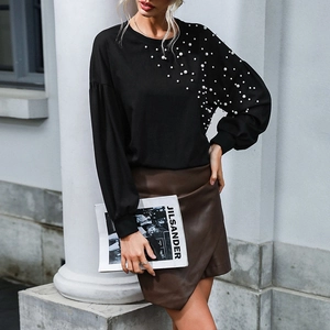 Women's black loose knit top with pearl embellishment on the shoulder and crew neck