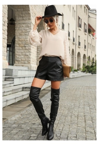 Detail of V-neck chiffon shirt with textured polka dot sleeves and faux leather shorts