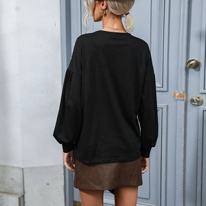 Women's black loose knit top with crew neck and lantern sleeves shown from behind