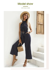 Detailed view of polka dot halter neck jumpsuit with a belted waist in navy blue