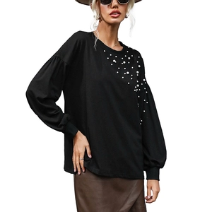 Women's black knit top with pearl accents and lantern sleeves on white background