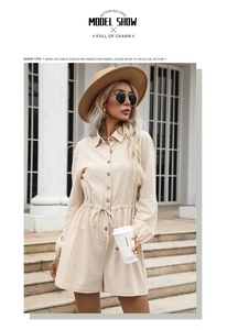 Detail view of the drawstring waist and button closure on this beige cotton linen romper