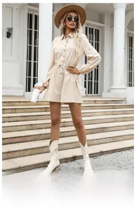 Detailed close-up of beige drawstring romper featuring shirt collar and wooden buttons