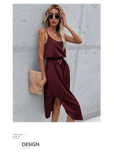 Detail of wine red satin midi dress featuring a side slit and elegant ribbon waist tie