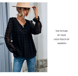 Detail of V-neck black chiffon blouse with textured polka dots and elastic cuffs