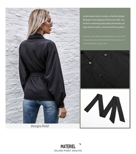 Detail view of women's black long sleeve lapel shirt featuring front pocket and matching belt