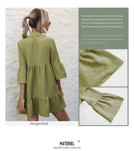 Detail of sage green tiered dress featuring waffle texture and ruffled bell sleeves