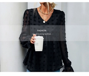 Detail of black V-neck Swiss dot chiffon blouse showing ruffle sleeves on model
