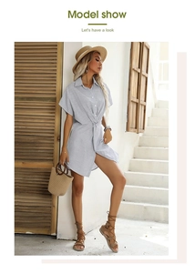 Dettaglio dell'abito a camicia a righe blu con nodo in vita ed elegante spacco laterale