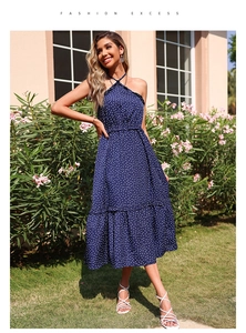 Detailed view of the halter neck chain and white polka dots on a navy summer midi dress