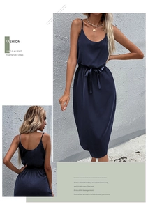 Detailed view of a dark blue satin slip midi dress with waist tie and glossy finish