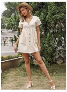 Detail of light beige cotton linen shirt dress featuring V-neck and wooden buttons