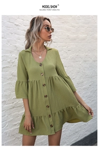 Detailed macro view of olive green textured mini dress with buttons and bell sleeves