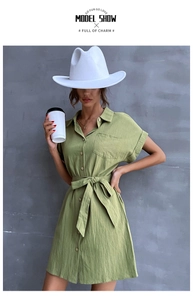 Close-up of a green short-sleeve cotton linen dress with a waist drawstring and buttons