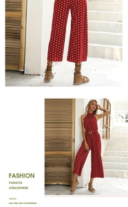 Close-up detail of red polka dot halter jumpsuit with matching waist belt and wide legs
