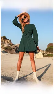Dettaglio dell'abito a maniche lunghe in chiffon verde scuro con cintura in vita