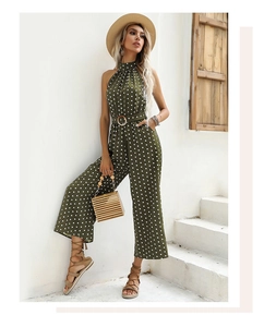 Detail of army green polka dot jumpsuit featuring a halter neck and round buckle waist belt