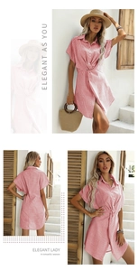 Dettaglio di un abito a camicia a righe bianche e rosse con vita intrecciata e maniche a pipistrello