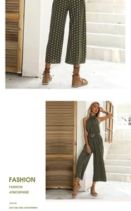 Detail view of dark green polka dot halter jumpsuit featuring a belted waist with buckle