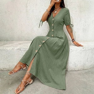 Detail of V-neck cotton linen dress with wooden buttons and tied cuffs in sage green