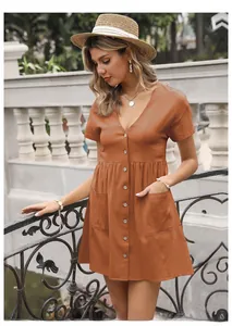 Detailed close-up of a V-neck caramel linen dress with wooden buttons and large side pockets