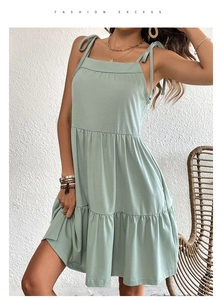 Détail de la robe courte vert sauge à volants avec des bretelles à nouer ajustables