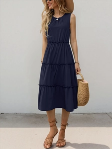 Dettaglio di un abito midi senza maniche blu navy con vita arricciata e gonna a balze