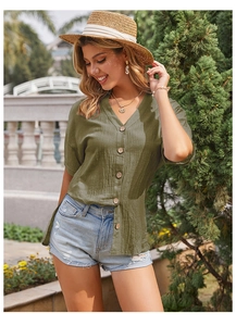 Dettaglio camicia in lino verde militare con scollo a V e bottoni in legno rustici