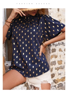 Dettaglio della camicetta blu navy a maniche corte con motivo metallico a foglie dorate